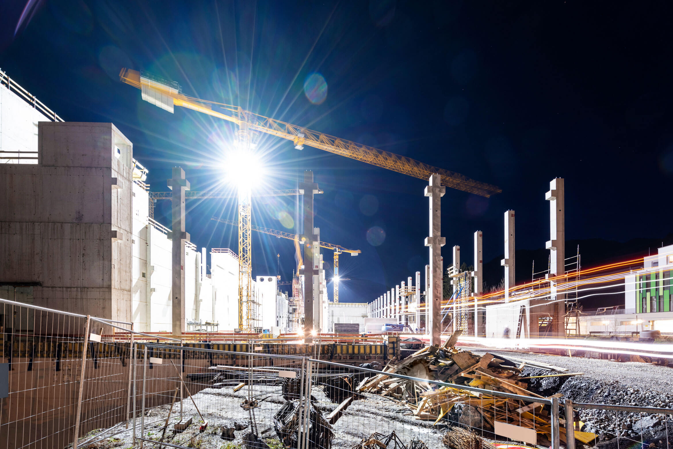 Baustelle mit drei Baukränen durch den Zaun abgeriegelt